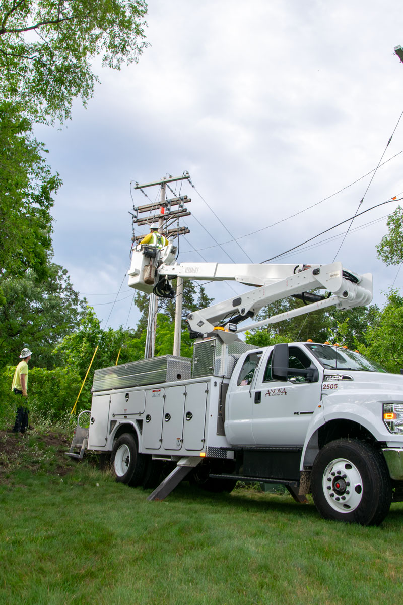 worker in a bucket truck checking powerlines